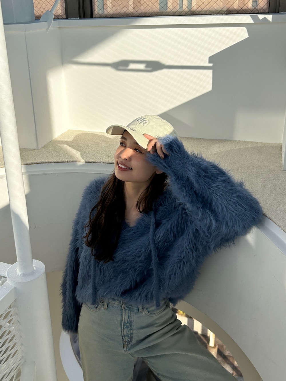 ブルー系のニット/セーター、ブルー系のデニムパンツを着用したレディースの冬コーディネートの3枚目の写真