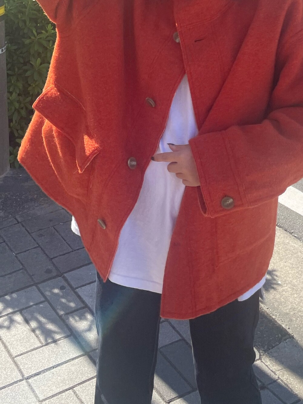 ホワイト系のTシャツ/カットソー、オレンジ系のブルゾン、ブルー系のデニムパンツを着用したレディースの秋コーディネートの4枚目の写真