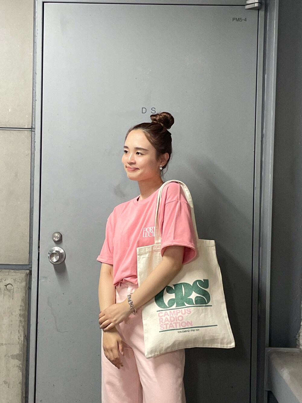 ピンク系のデニムパンツ、ピンク系のTシャツ/カットソー、グリーン系のトートバッグを着用したレディースの夏コーディネートの5枚目の写真