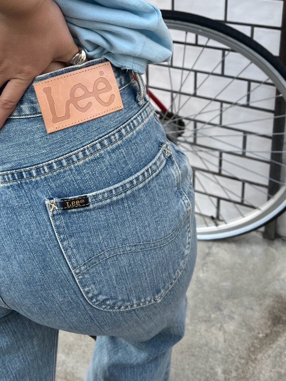 ブルー系のTシャツ/カットソー、ブルー系のデニムパンツ、シルバー系のサンダルを着用したレディースの春コーディネートの5枚目の写真