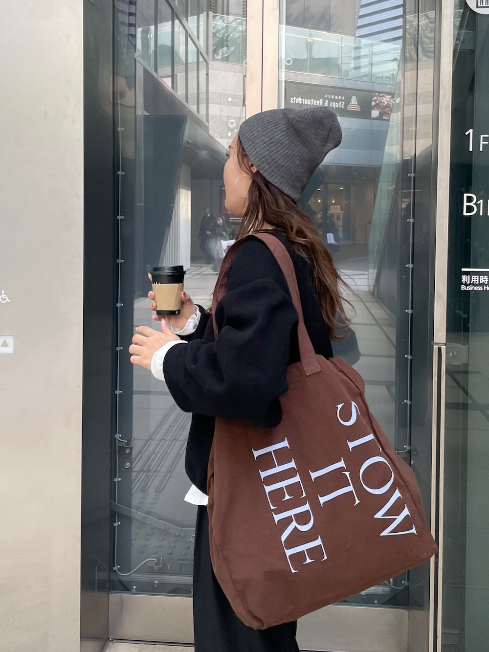 ブラック系のニット/セーター、ホワイト系のTシャツ/カットソー、ブラウン系のトートバッグを着用したレディースの冬コーディネートの6枚目の写真