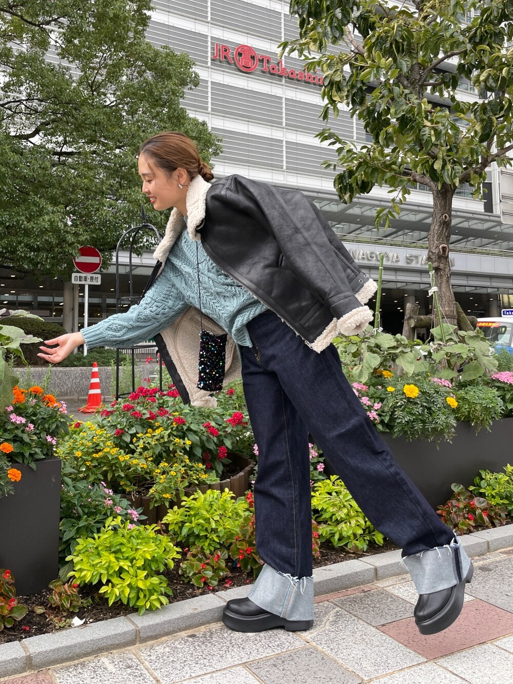 ブルー系のニット/セーター、ブルー系のデニムパンツ、その他のショルダーバッグを着用したレディースの秋コーディネートの6枚目の写真