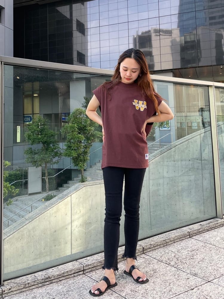 ブラック系のデニムパンツ、ブラック系のサンダル、ブラウン系のTシャツ/カットソーを着用したレディースの夏コーディネートの2枚目の写真