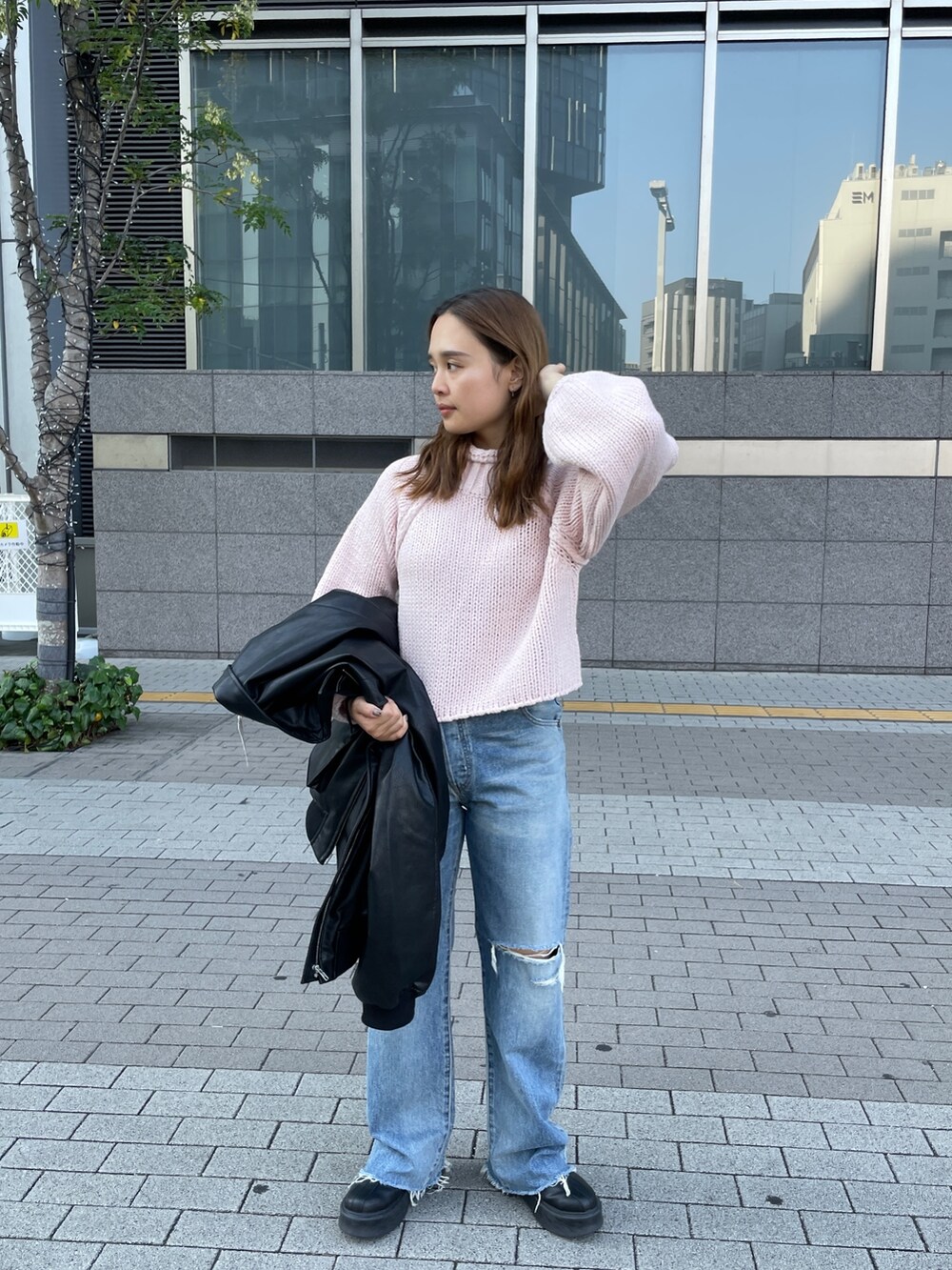 ピンク系のニット/セーター、ブルー系のデニムパンツを着用したレディースの秋コーディネートの2枚目の写真