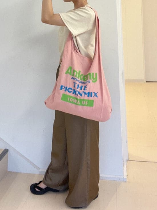 ピンク系のエコバッグ/サブバッグ、ブラウン系のその他パンツ、ホワイト系のTシャツ/カットソーを着用したレディースの夏コーディネートの6枚目の写真