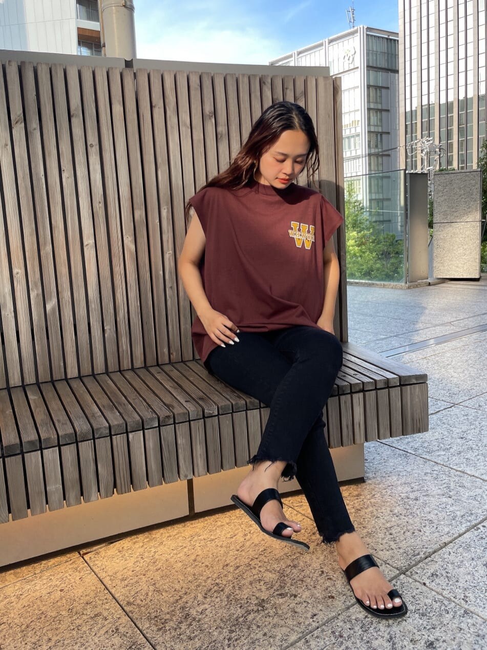 ブラック系のデニムパンツ、ブラック系のサンダル、ブラウン系のTシャツ/カットソーを着用したレディースの夏コーディネートの3枚目の写真