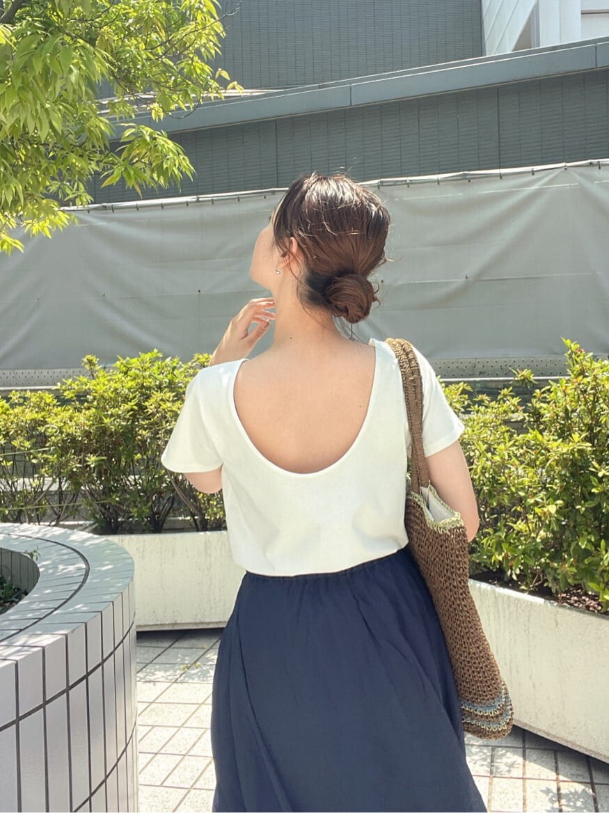 ブラウン系のトートバッグ、ホワイト系のTシャツ/カットソー、ブルー系のスカートを着用したレディースの春コーディネートの6枚目の写真