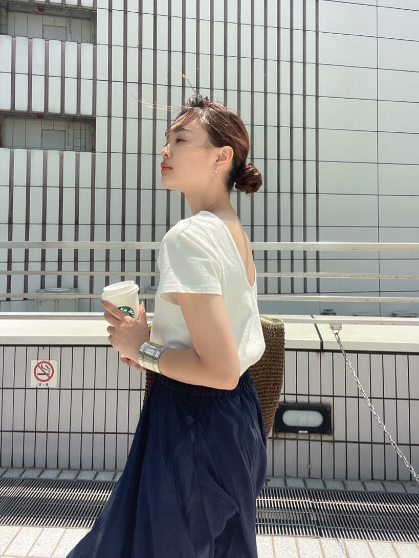 ブラウン系のトートバッグ、ホワイト系のTシャツ/カットソー、ブルー系のスカートを着用したレディースの春コーディネートの8枚目の写真