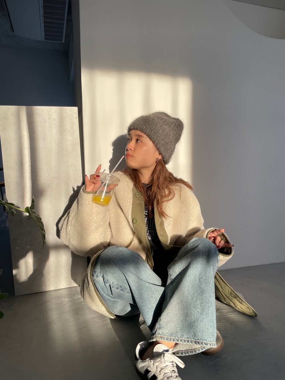 ホワイト系のブルゾン、ブルー系のデニムパンツを着用したレディースの冬コーディネートの3枚目の写真