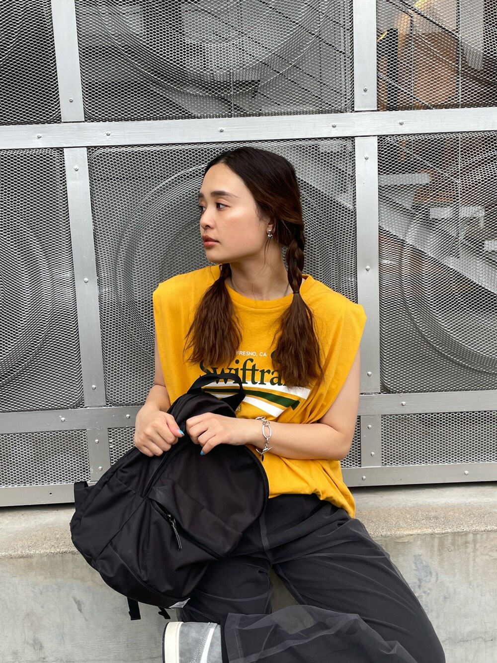 イエロー系のTシャツ/カットソー、グレー系のその他パンツを着用したレディースの春コーディネートの2枚目の写真