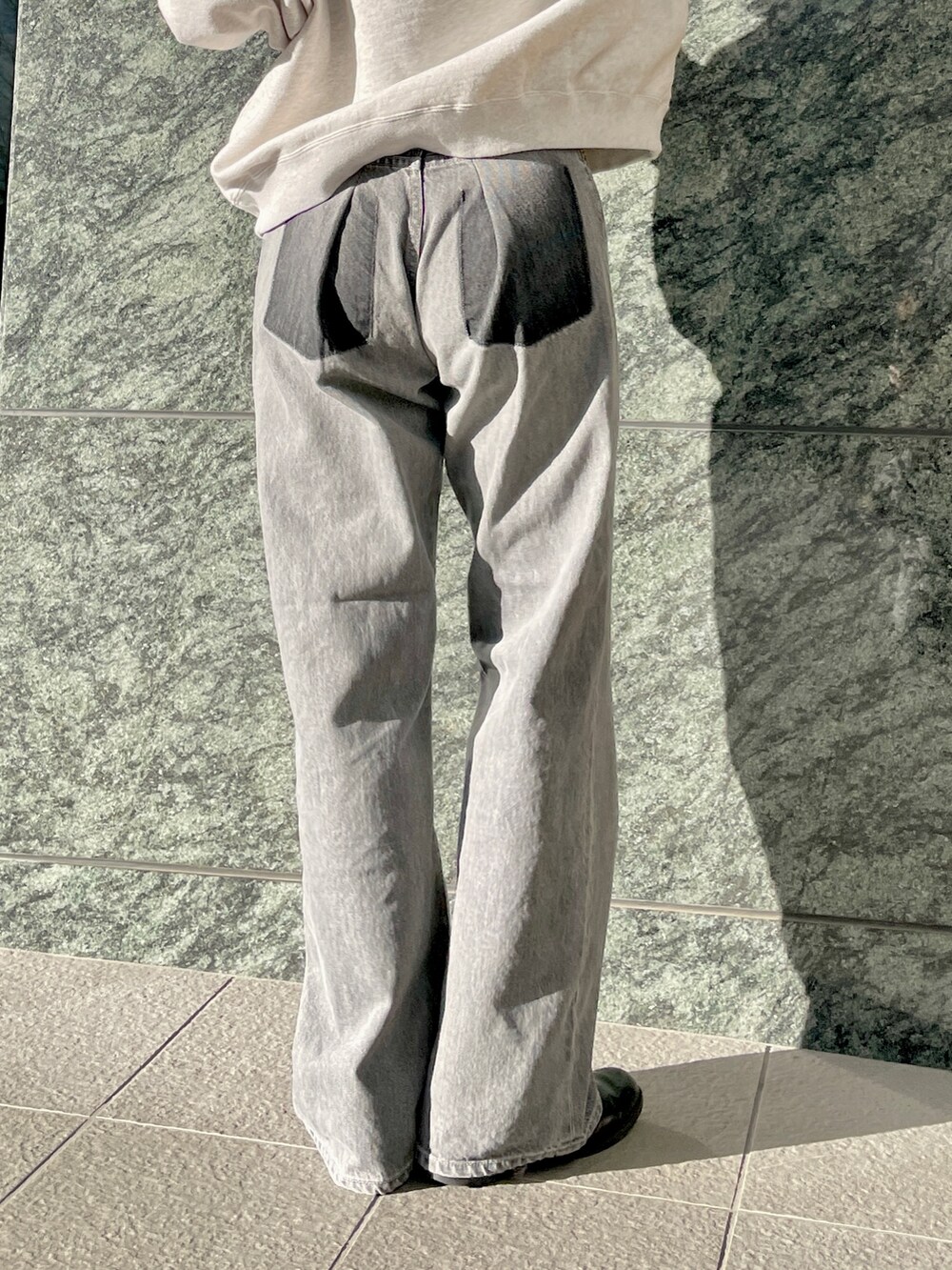 ブラック系のデニムパンツ、グレー系のパーカーを着用したレディースの冬コーディネートの10枚目の写真