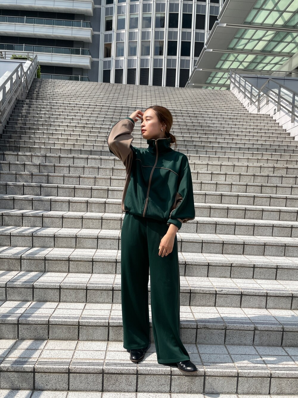 グリーン系のブルゾン、グリーン系のその他パンツ、ホワイト系のダウンベストを着用したレディースの秋コーディネートの9枚目の写真