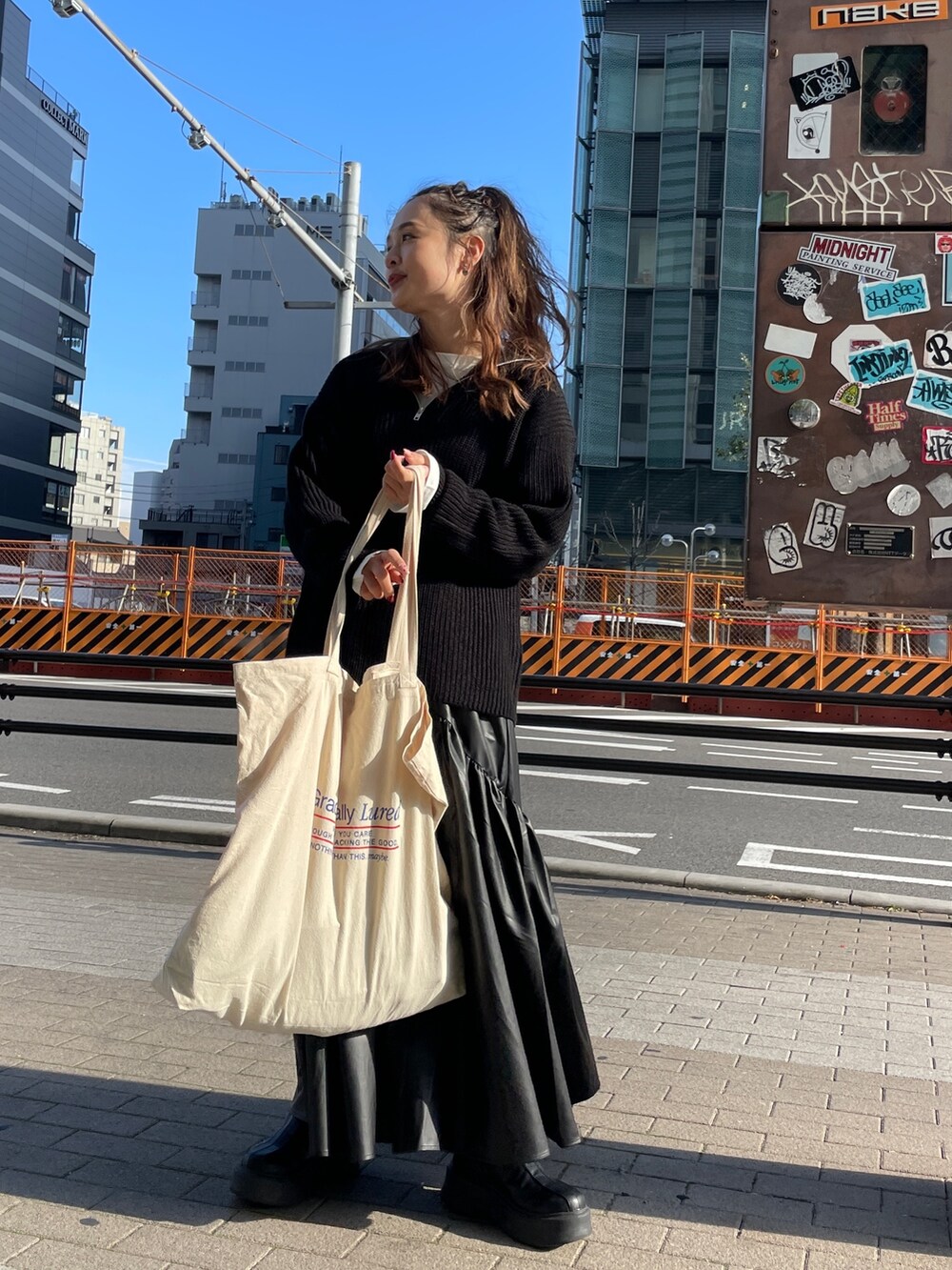 ブラック系のニット/セーター、ホワイト系のTシャツ/カットソー、ブラック系のスカートを着用したレディースの冬コーディネートの2枚目の写真