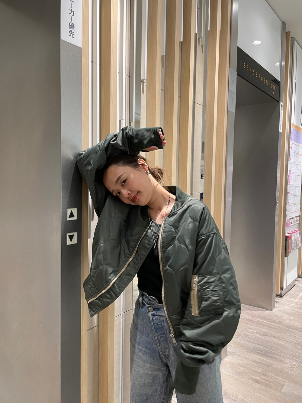 ブルー系のデニムパンツ、シルバー系のパンプス、ベージュ系のブルゾンを着用したレディースの秋コーディネートの4枚目の写真