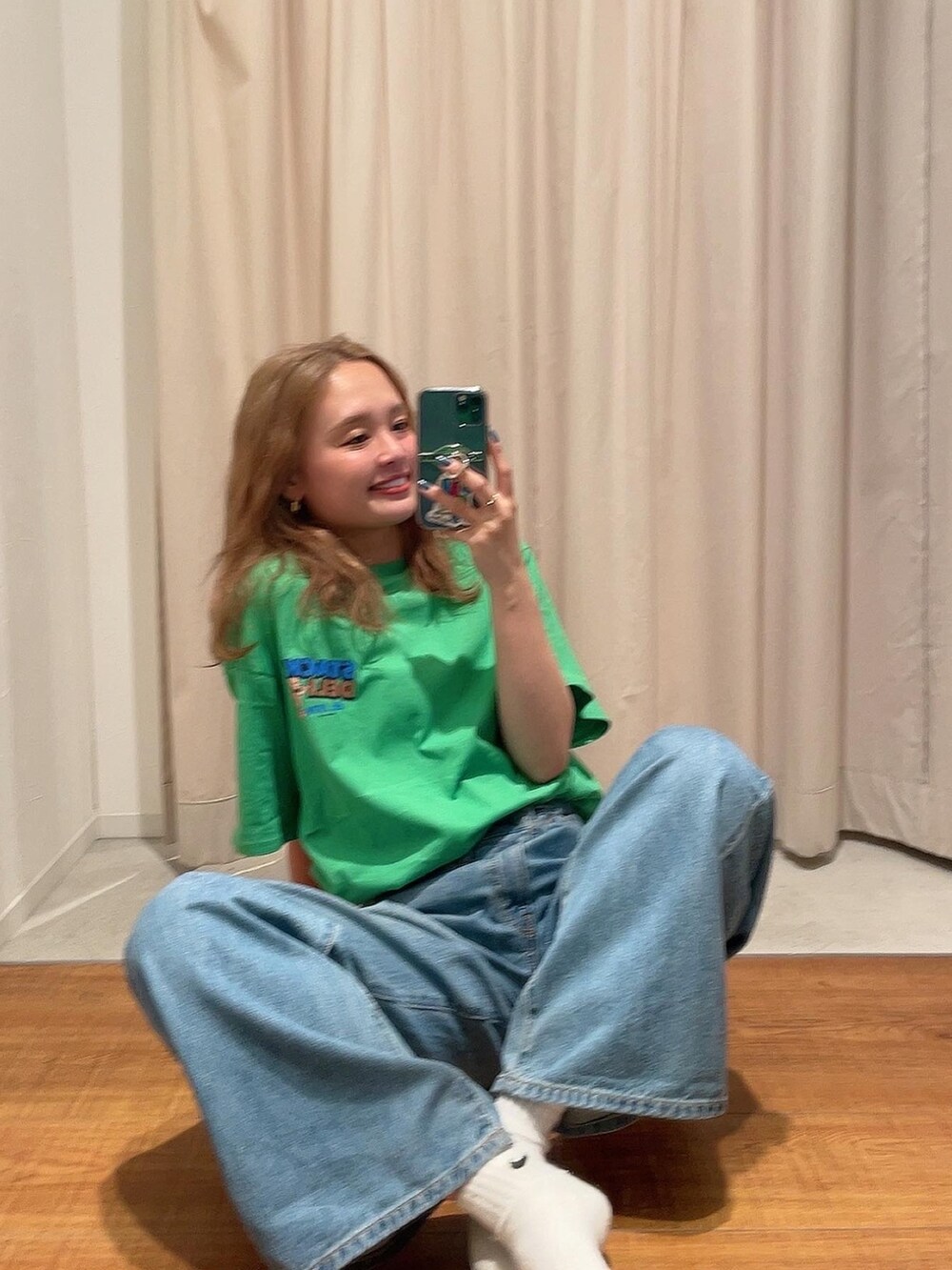 ブルー系のデニムパンツ、グリーン系のTシャツ/カットソーを着用したレディースの春コーディネートの2枚目の写真