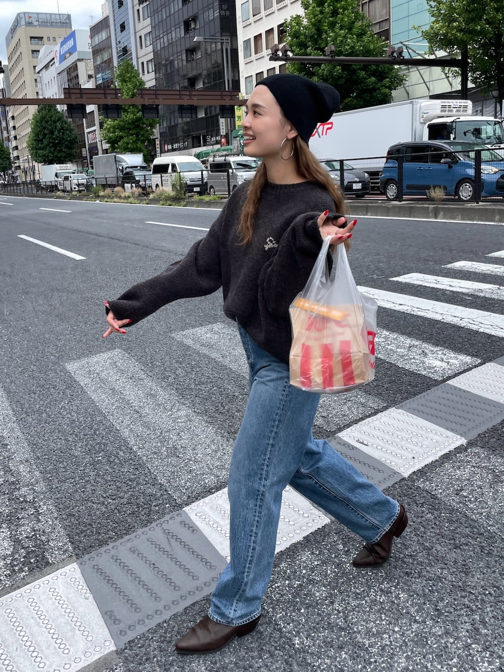 グレー系のニット/セーター、ブルー系のデニムパンツ、ブラック系のニットキャップ/ビーニーを着用したレディースの秋コーディネートの2枚目の写真