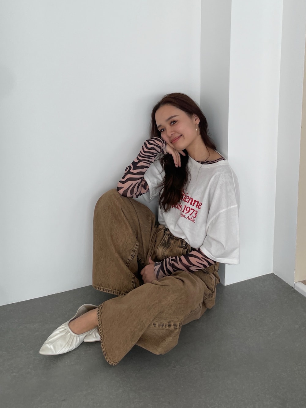 ブラウン系のデニムパンツ、ホワイト系のTシャツ/カットソー、ブラック系のTシャツ/カットソーを着用したレディースの春コーディネートの3枚目の写真