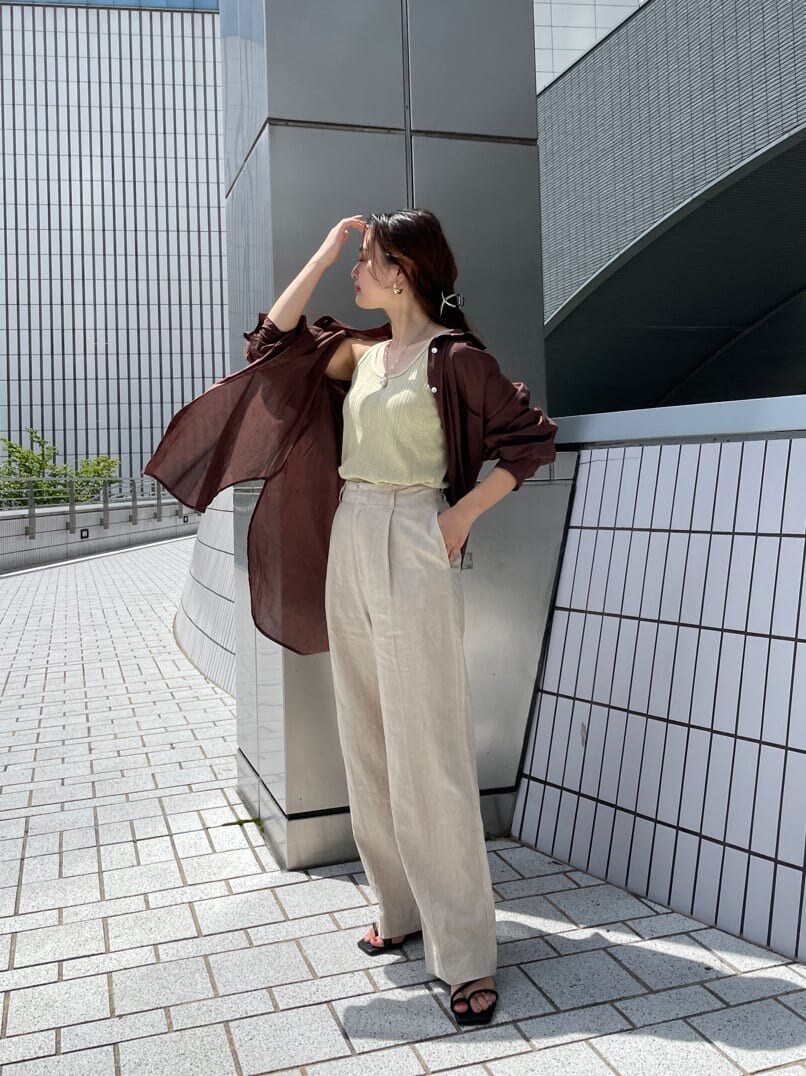 グリーン系のタンクトップ、ブラック系のサンダル、ホワイト系のその他パンツを着用したレディースの夏コーディネートの3枚目の写真