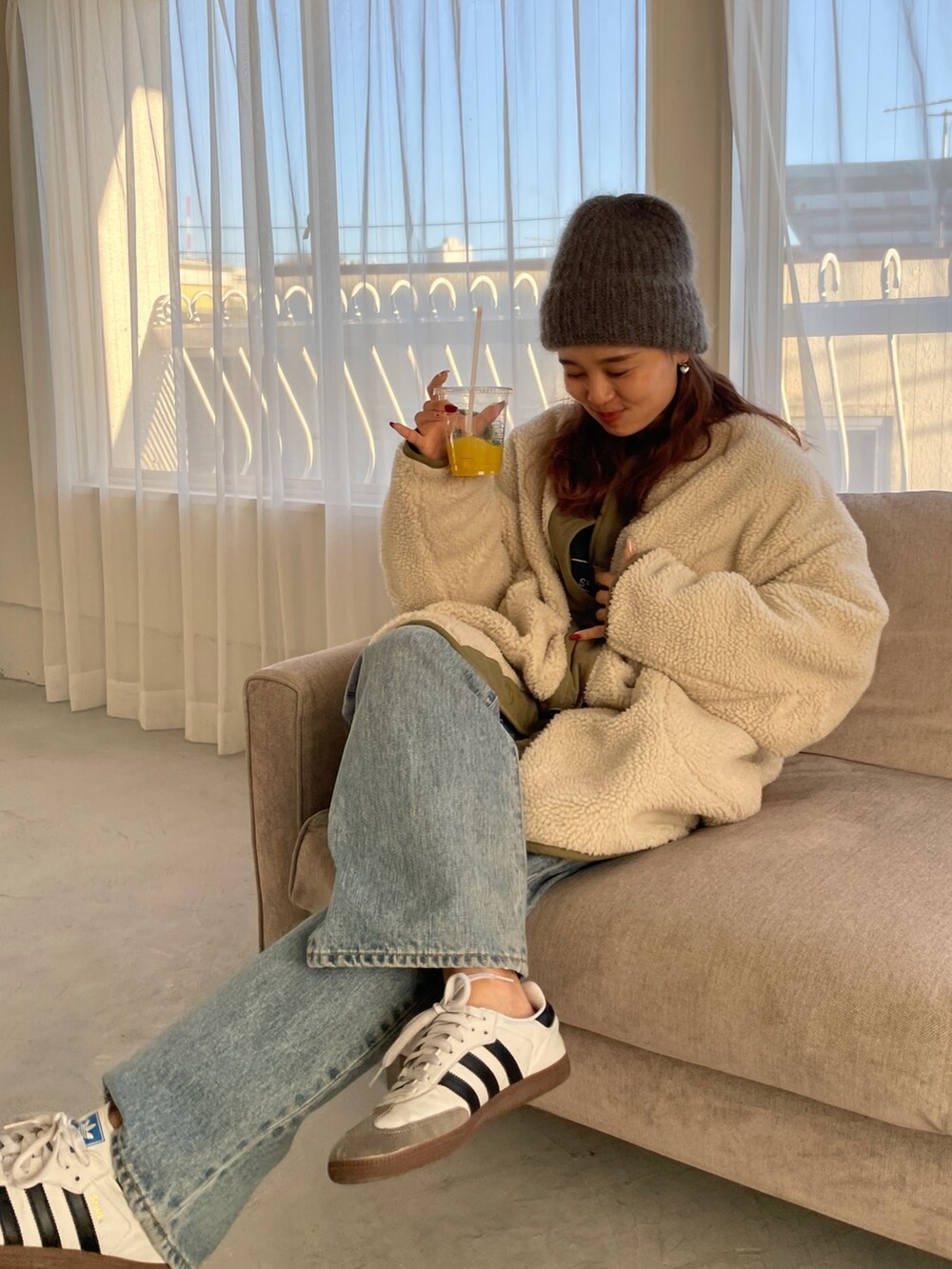 ホワイト系のブルゾン、ブルー系のデニムパンツを着用したレディースの冬コーディネートの6枚目の写真