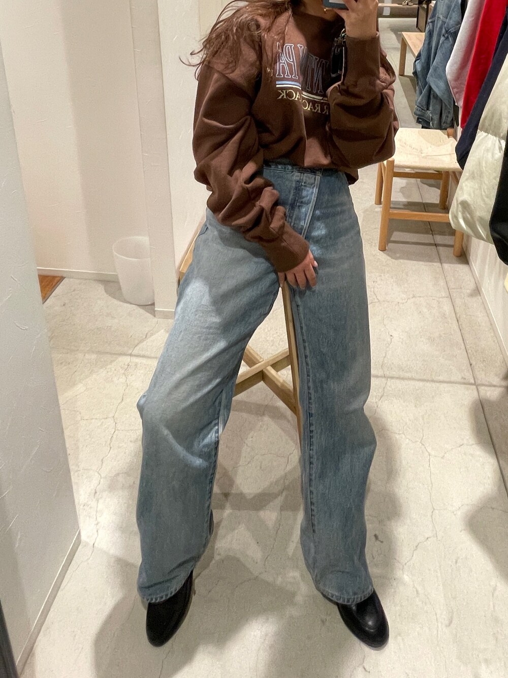 ホワイト系のスウェット、ブルー系のデニムパンツを着用したレディースの冬コーディネートの5枚目の写真