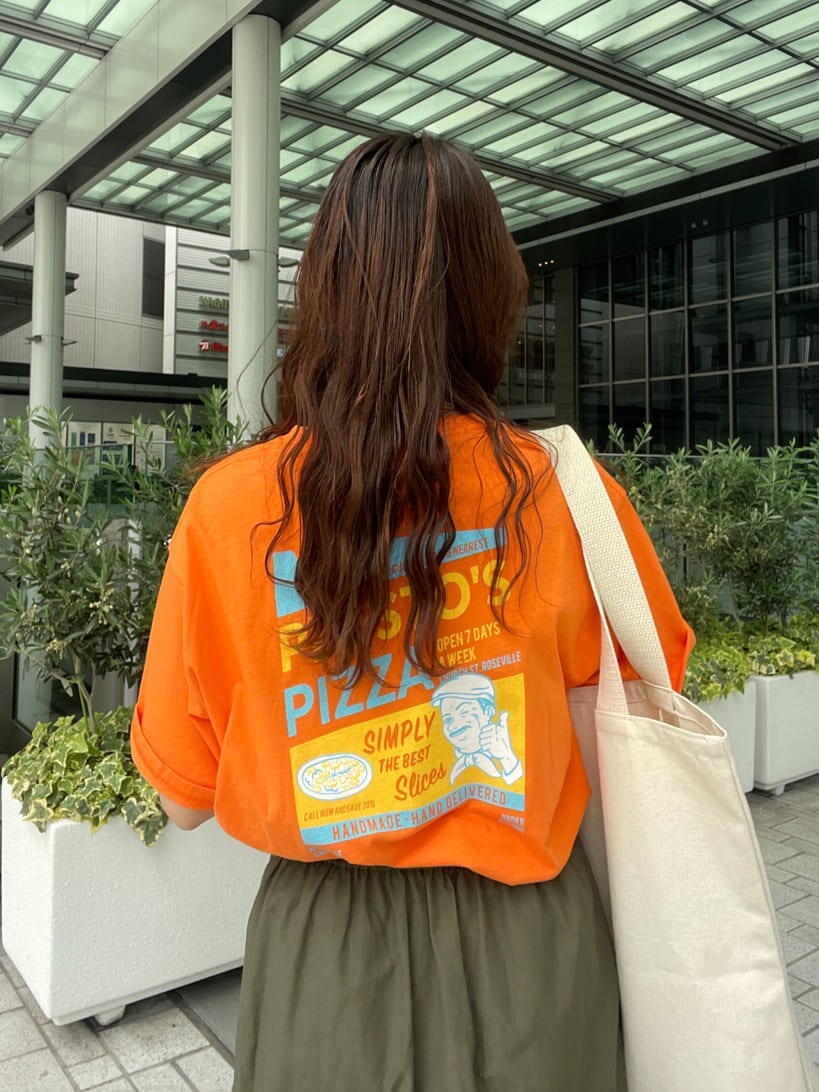 ベージュ系のスカート、オレンジ系のTシャツ/カットソー、グリーン系のハンドバッグを着用したレディースの春コーディネートの7枚目の写真