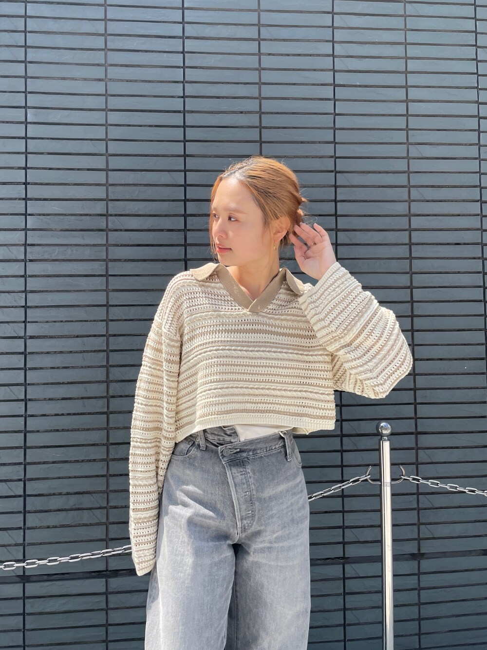 ブラック系のデニムパンツ、ベージュ系のニット/セーターを着用したレディースの春コーディネートの6枚目の写真