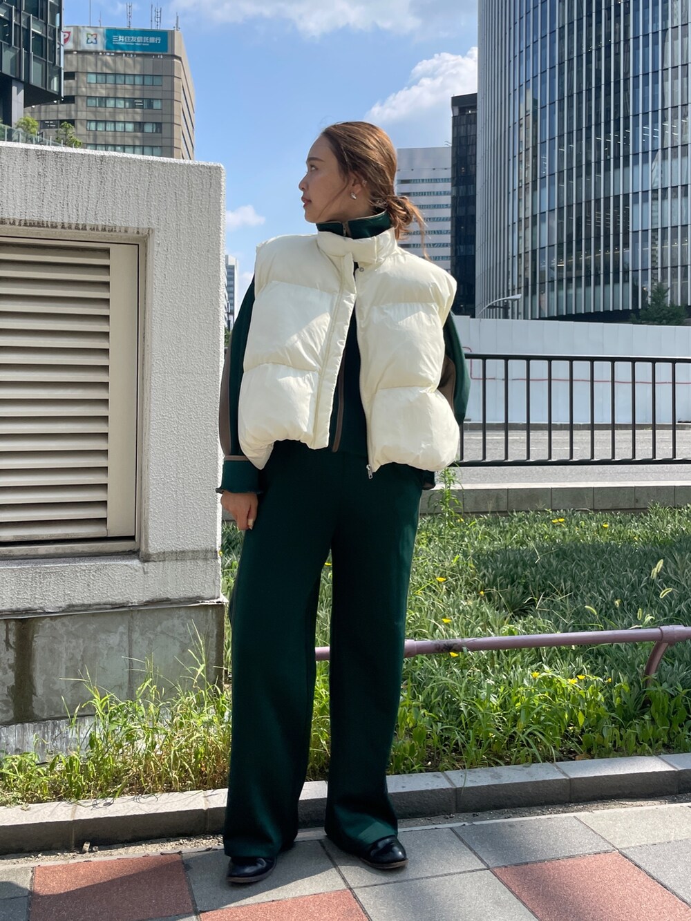 グリーン系のブルゾン、グリーン系のその他パンツ、ホワイト系のダウンベストを着用したレディースの秋コーディネートの4枚目の写真