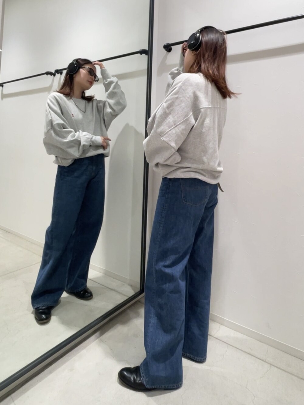 グレー系のスウェット、ブルー系のデニムパンツ、シルバー系のネックレスを着用したレディースの冬コーディネートの2枚目の写真
