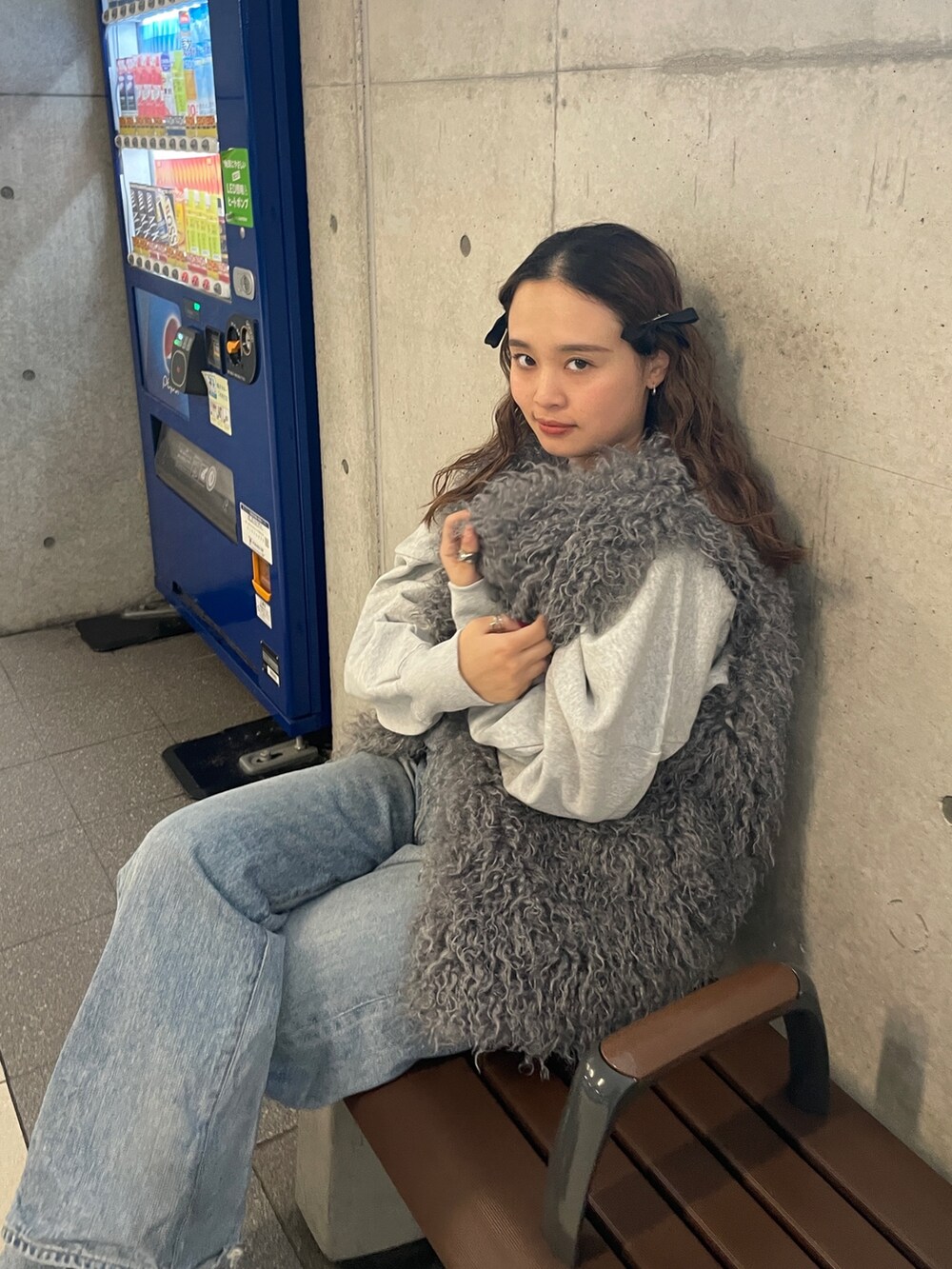 ブルー系のデニムパンツ、グレー系のスウェット、グレー系のベストを着用したレディースの冬コーディネートの9枚目の写真