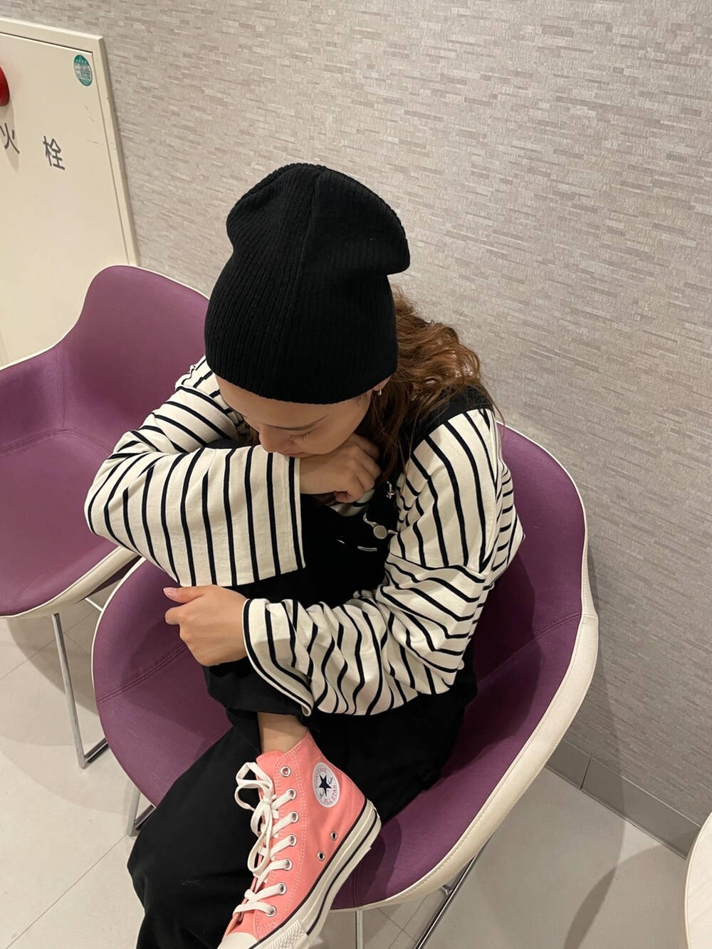 ブラック系のサロペット/オーバーオール、ブルー系のTシャツ/カットソー、ブラック系のニットキャップ/ビーニーを着用したレディースの秋コーディネートの4枚目の写真