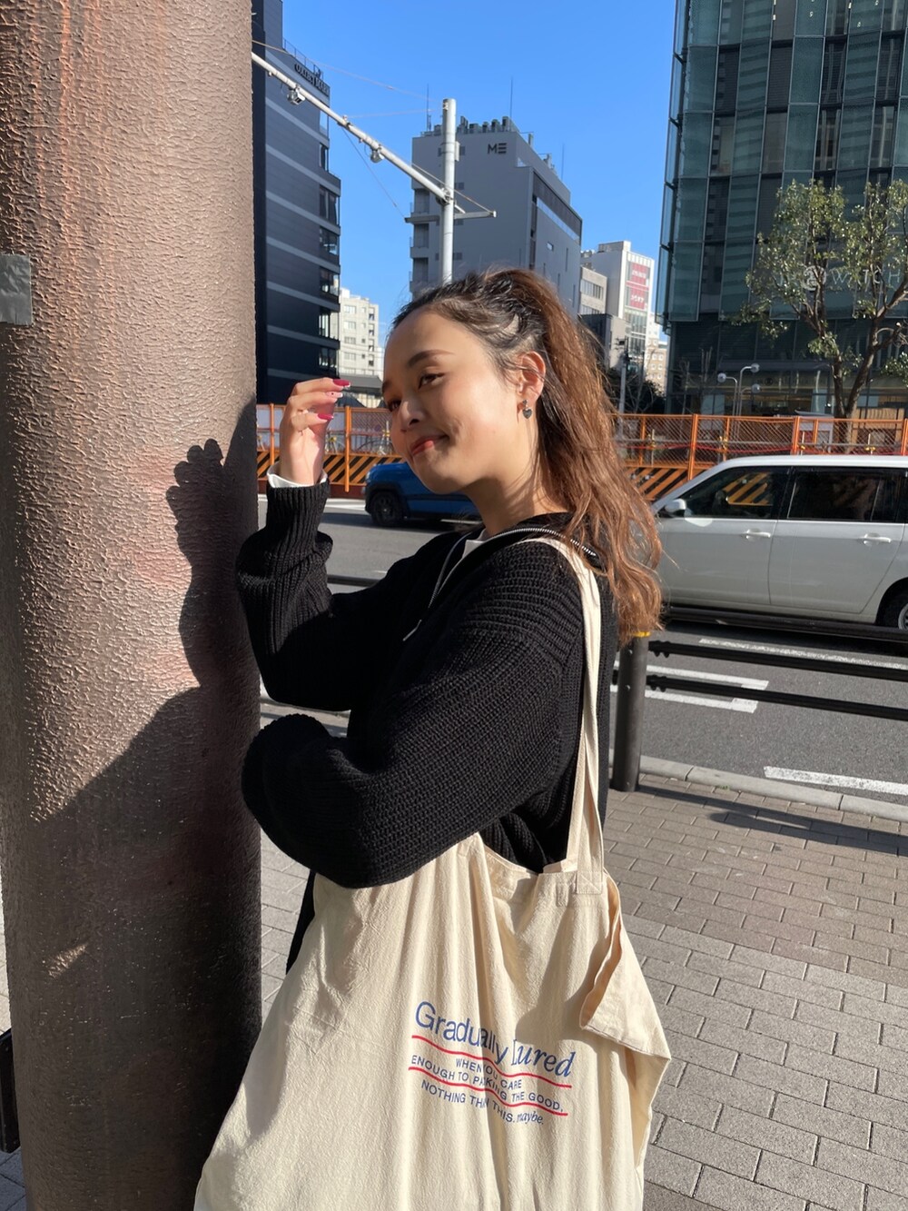 ブラック系のニット/セーター、ホワイト系のTシャツ/カットソー、ブラック系のスカートを着用したレディースの冬コーディネートの4枚目の写真