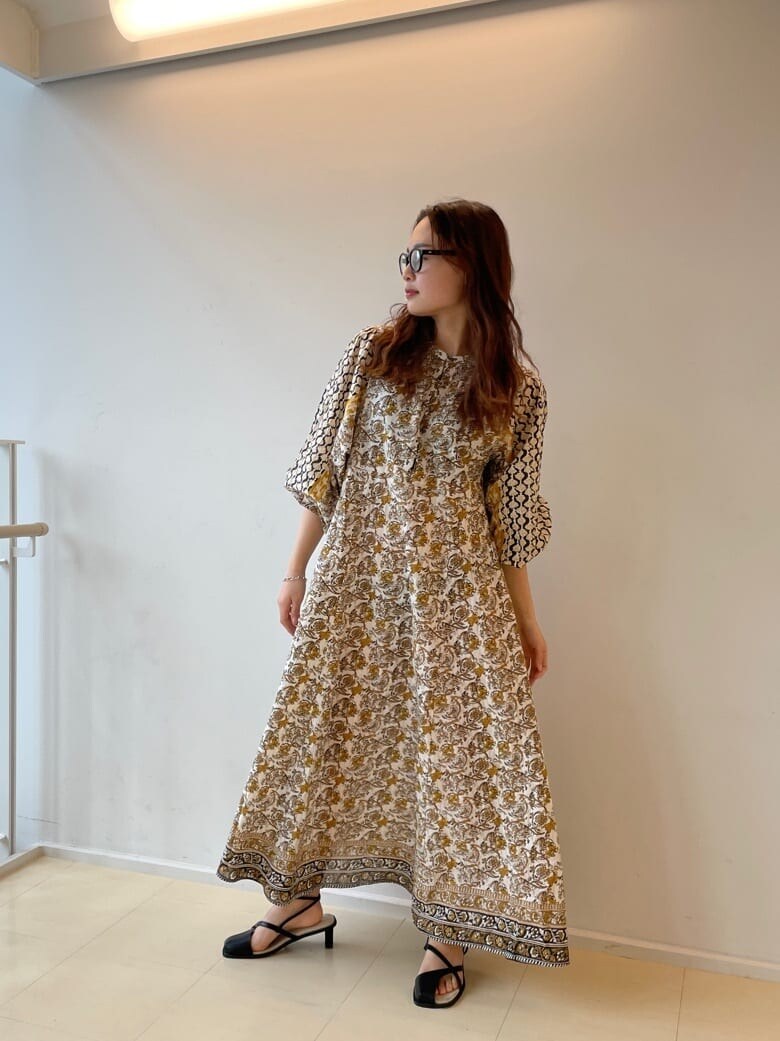 ホワイト系のワンピース、ブラック系のサンダル、ベージュ系のハットを着用したレディースの春コーディネートの2枚目の写真