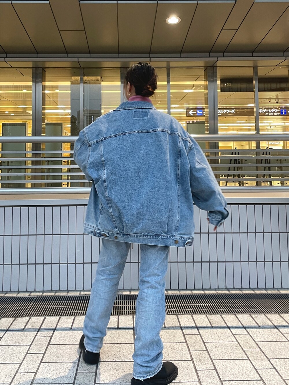 ブルー系のデニムジャケット、ピンク系のニット/セーター、ブルー系のデニムパンツを着用したレディースの冬コーディネートの6枚目の写真