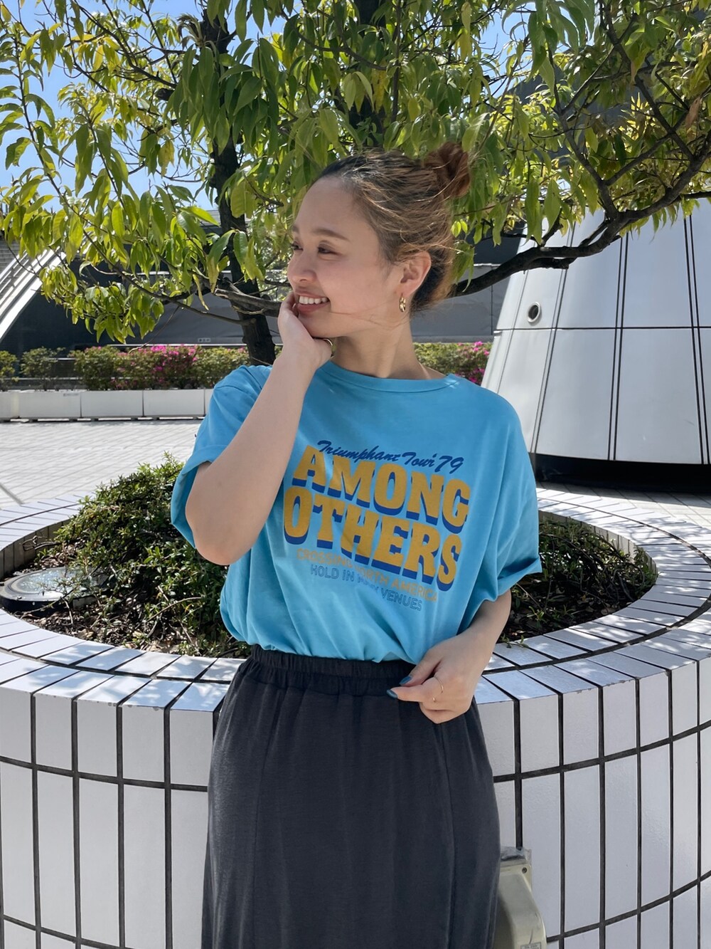 ブルー系のTシャツ/カットソー、グレー系のスカート、ブルー系のスニーカーを着用したレディースの春コーディネートの3枚目の写真