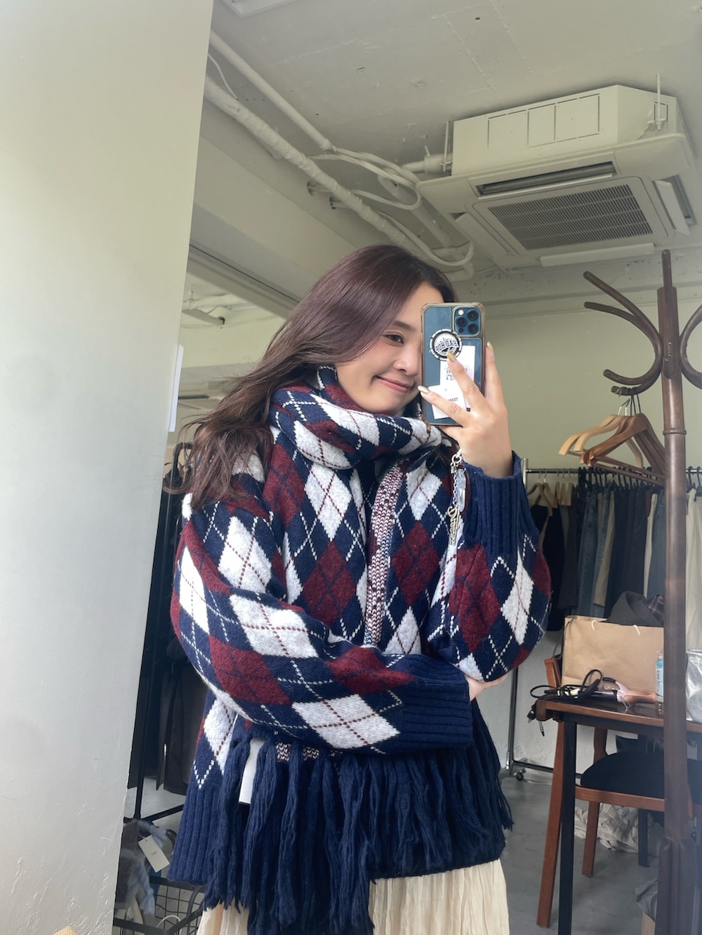 ブルー系のニット/セーター、ホワイト系のスカートを着用したレディースの秋コーディネートの3枚目の写真