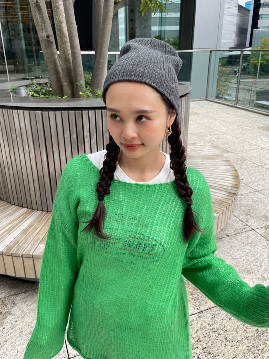 ブルー系のデニムパンツ、ホワイト系のTシャツ/カットソー、グリーン系のニット/セーターを着用したレディースの秋コーディネートの2枚目の写真