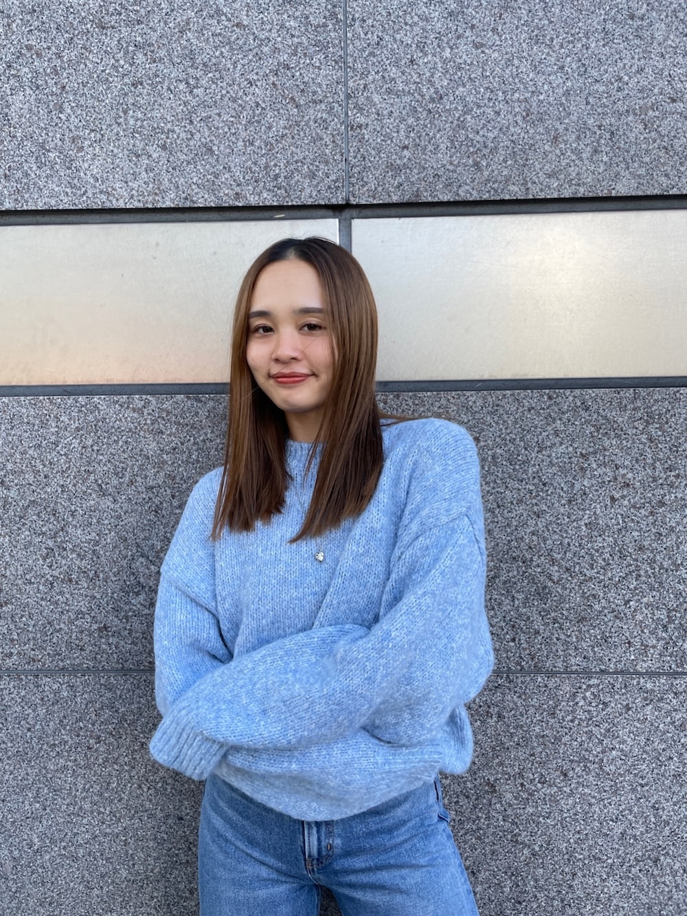 ブラック系のブルゾン、ブルー系のニット/セーター、ブルー系のデニムパンツを着用したレディースの秋コーディネートの3枚目の写真