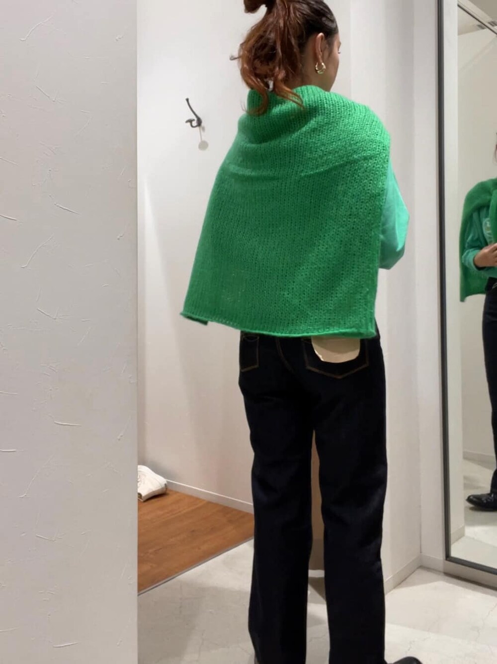 グリーン系のニット/セーター、グリーン系のTシャツ/カットソー、ブルー系のデニムパンツを着用したレディースの秋コーディネートの3枚目の写真