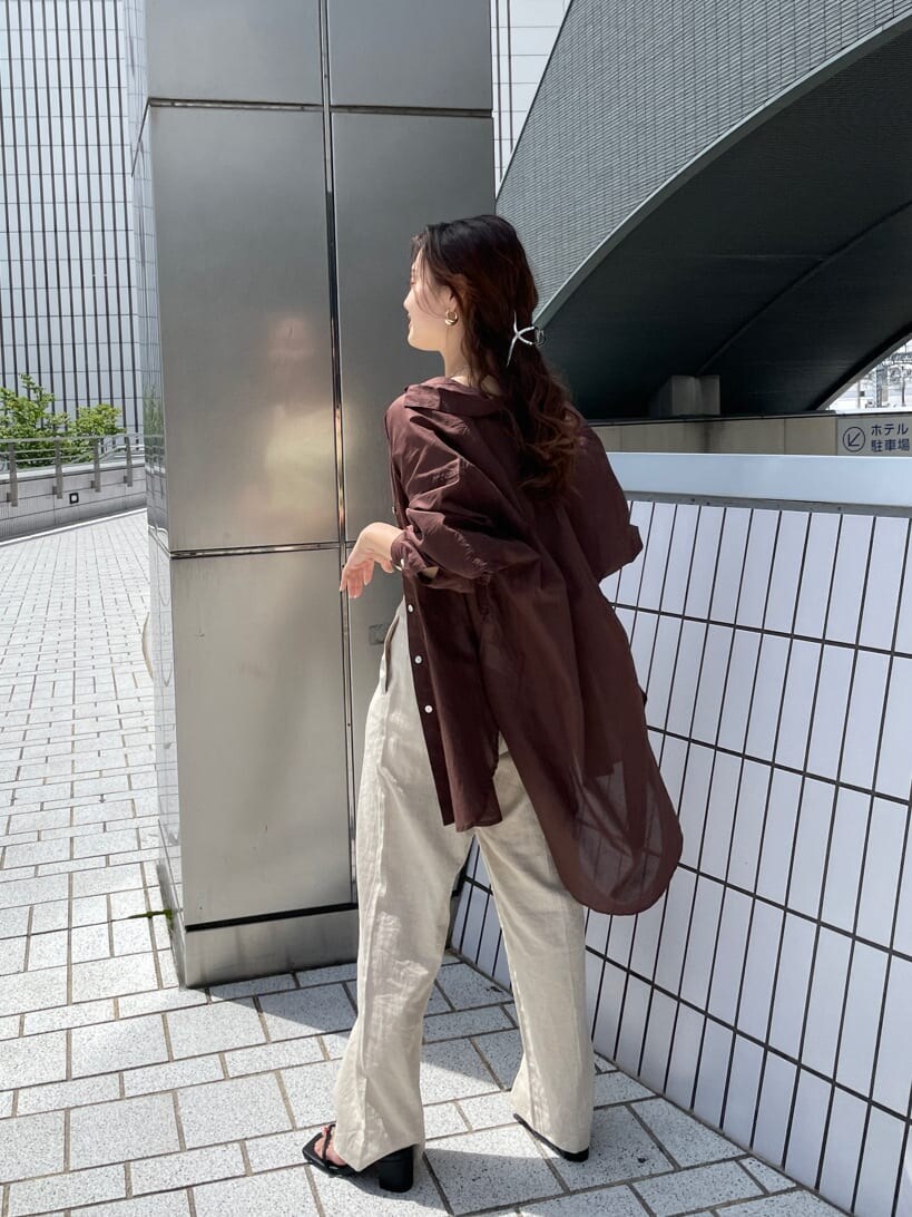 グリーン系のタンクトップ、ブラック系のサンダル、ホワイト系のその他パンツを着用したレディースの夏コーディネートの7枚目の写真