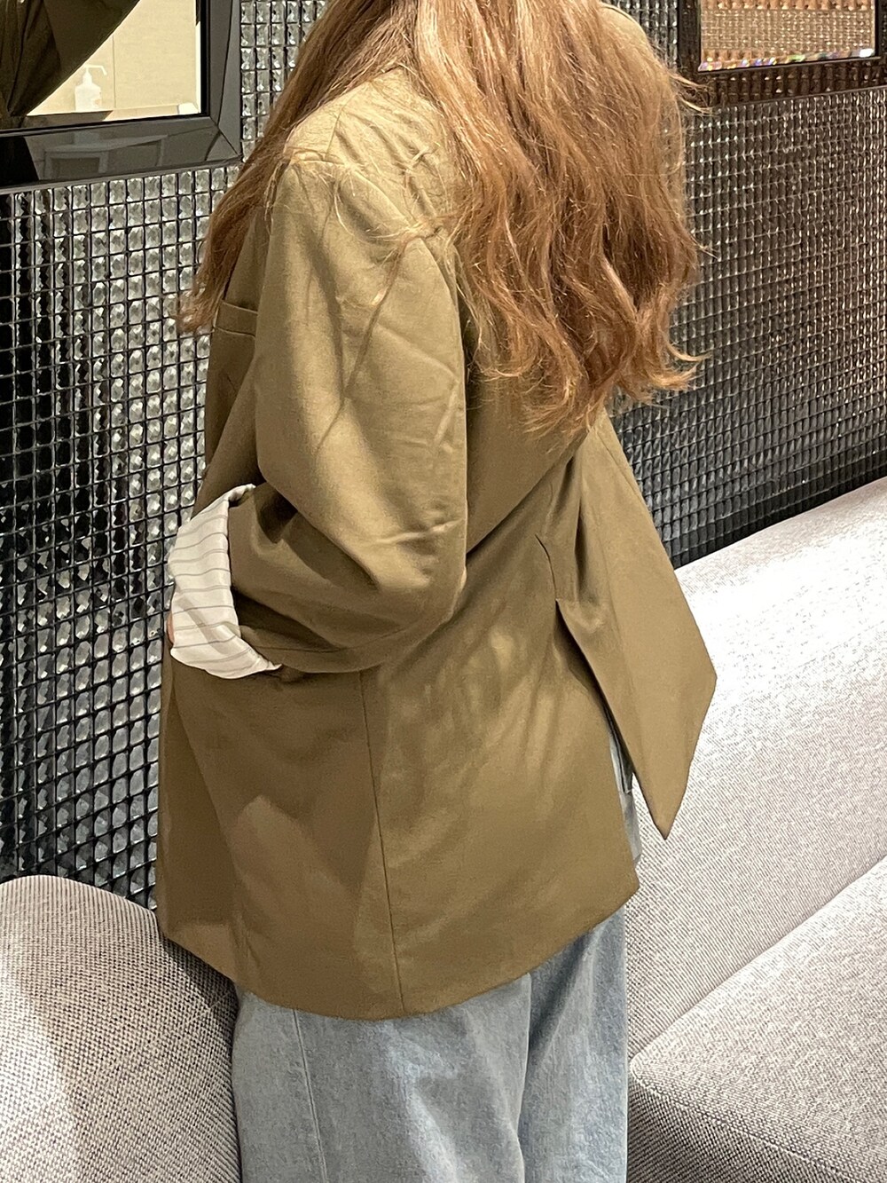 グリーン系のテーラードジャケット、ブルー系のデニムパンツ、グレー系のニットキャップ/ビーニーを着用したレディースの秋コーディネートの3枚目の写真