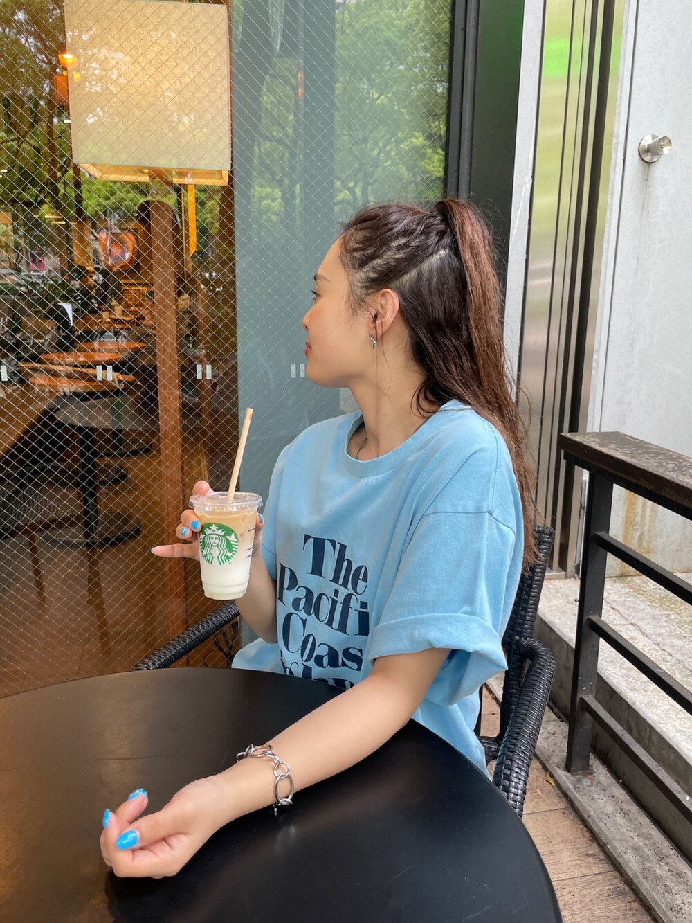 ブルー系のTシャツ/カットソー、ベージュ系のスカート、ブルー系のデニムパンツを着用したレディースの春コーディネートの2枚目の写真