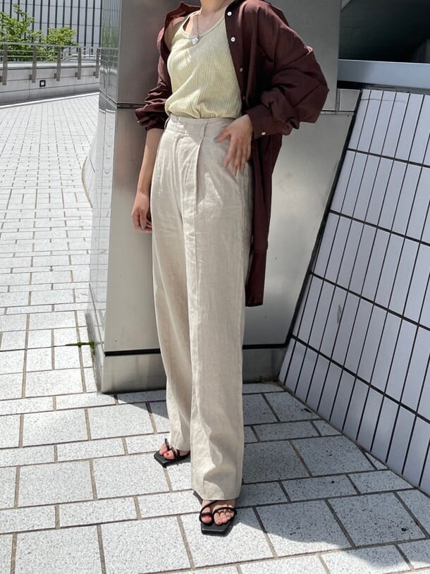 グリーン系のタンクトップ、ブラック系のサンダル、ホワイト系のその他パンツを着用したレディースの夏コーディネートの6枚目の写真