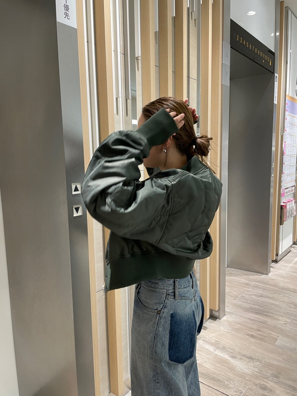 ブルー系のデニムパンツ、シルバー系のパンプス、ベージュ系のブルゾンを着用したレディースの秋コーディネートの3枚目の写真