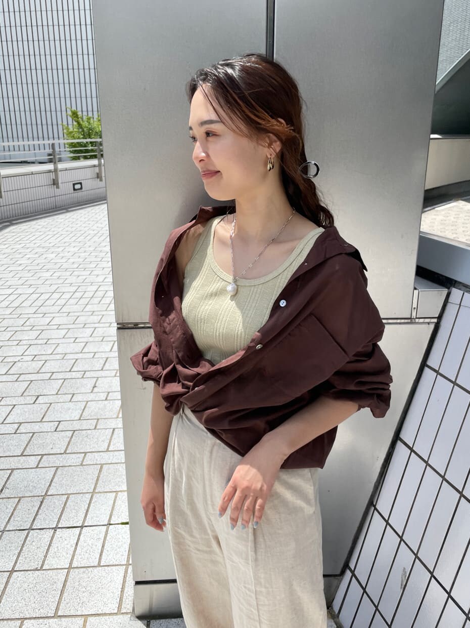 グリーン系のタンクトップ、ブラック系のサンダル、ホワイト系のその他パンツを着用したレディースの夏コーディネートの9枚目の写真