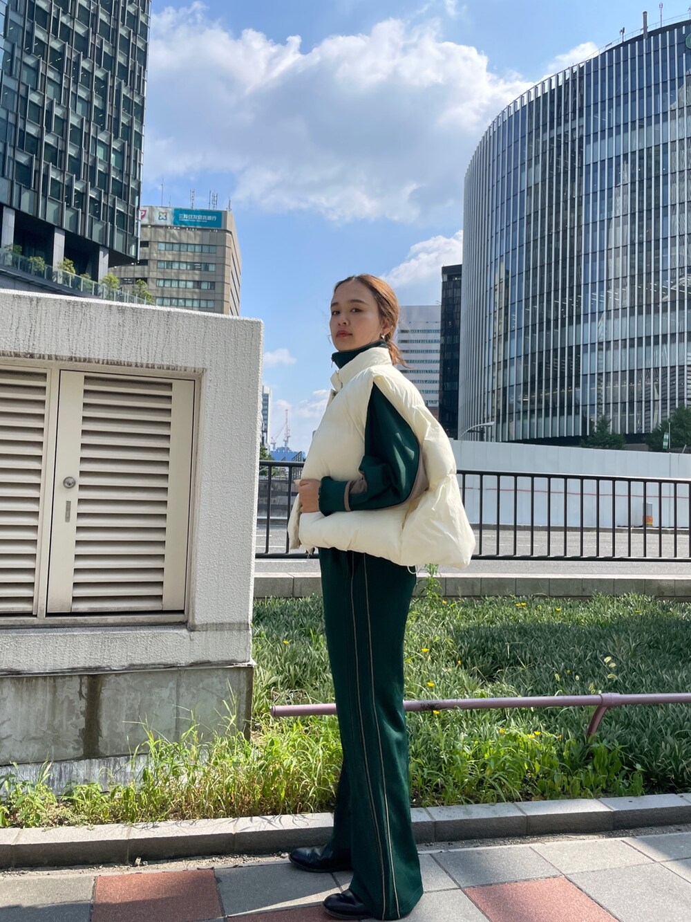 グリーン系のブルゾン、グリーン系のその他パンツ、ホワイト系のダウンベストを着用したレディースの秋コーディネートの2枚目の写真