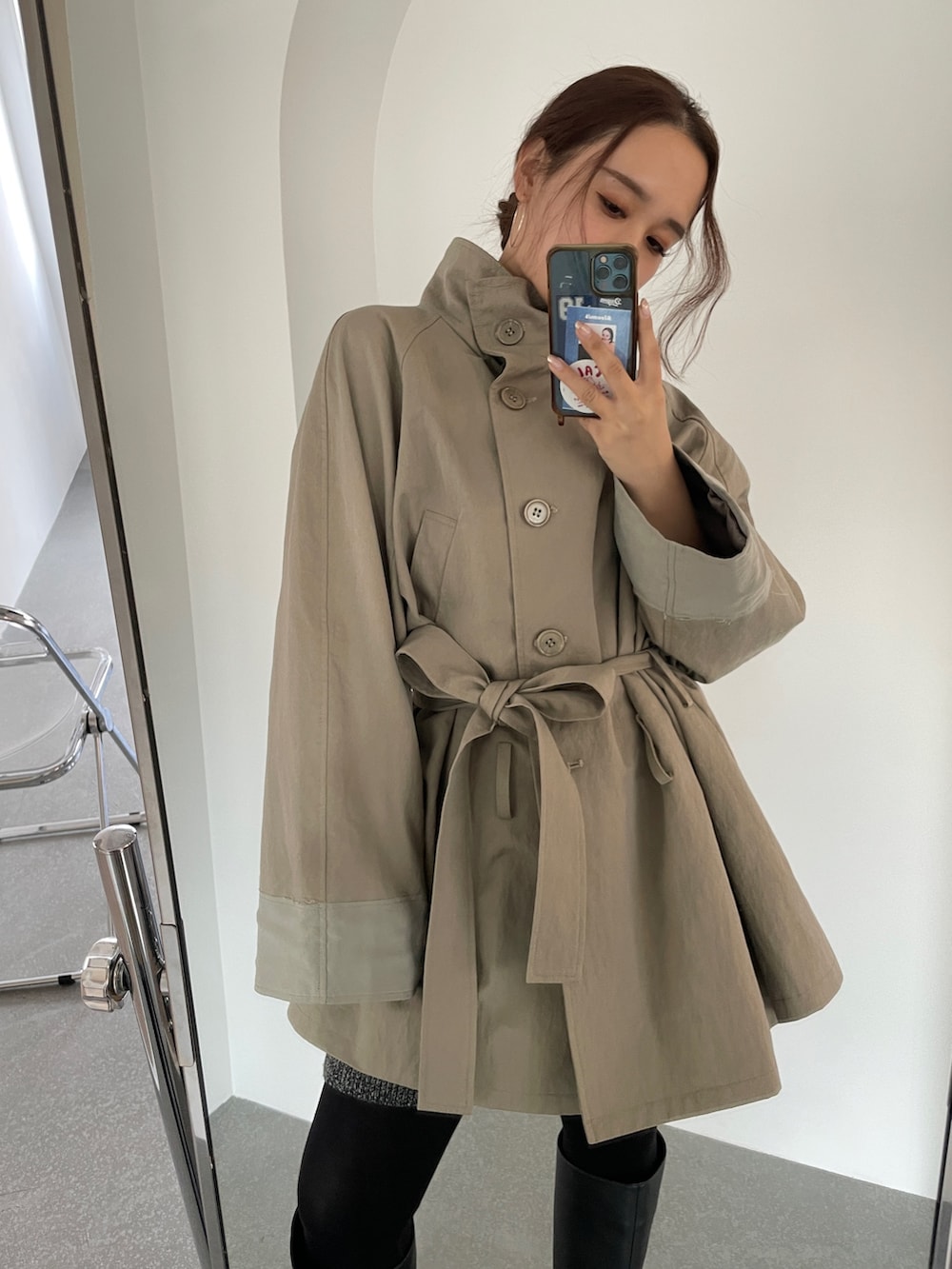 グリーン系のトレンチコートを着用したレディースの冬コーディネートの2枚目の写真