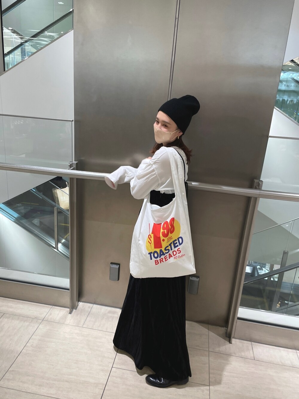 ホワイト系のTシャツ/カットソー、ブラック系のワンピース、ホワイト系のエコバッグ/サブバッグを着用したレディースの冬コーディネートの6枚目の写真