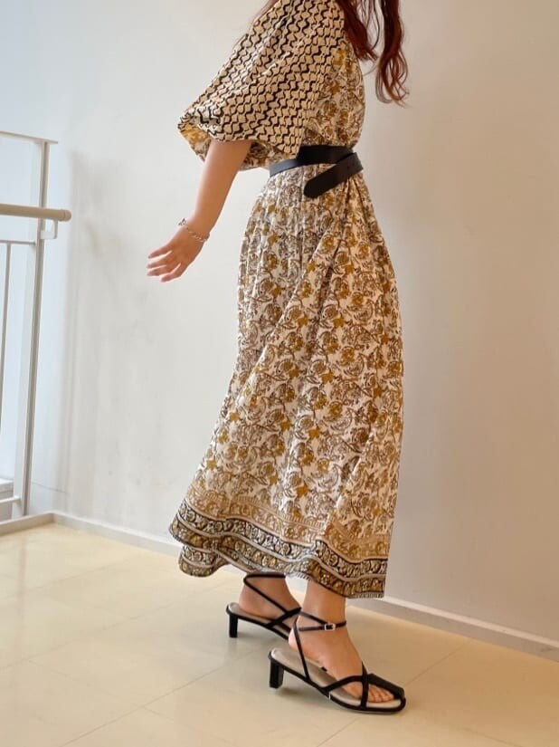 ホワイト系のワンピース、ブラック系のサンダル、ベージュ系のハットを着用したレディースの春コーディネートの5枚目の写真