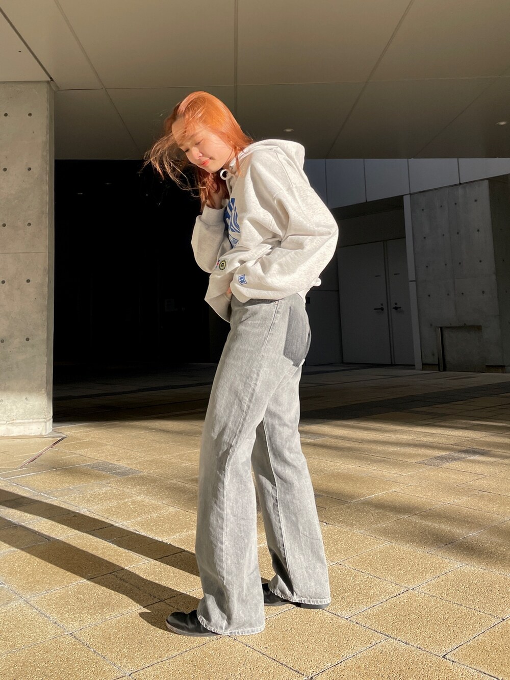 ブラック系のデニムパンツ、グレー系のパーカーを着用したレディースの冬コーディネートの3枚目の写真