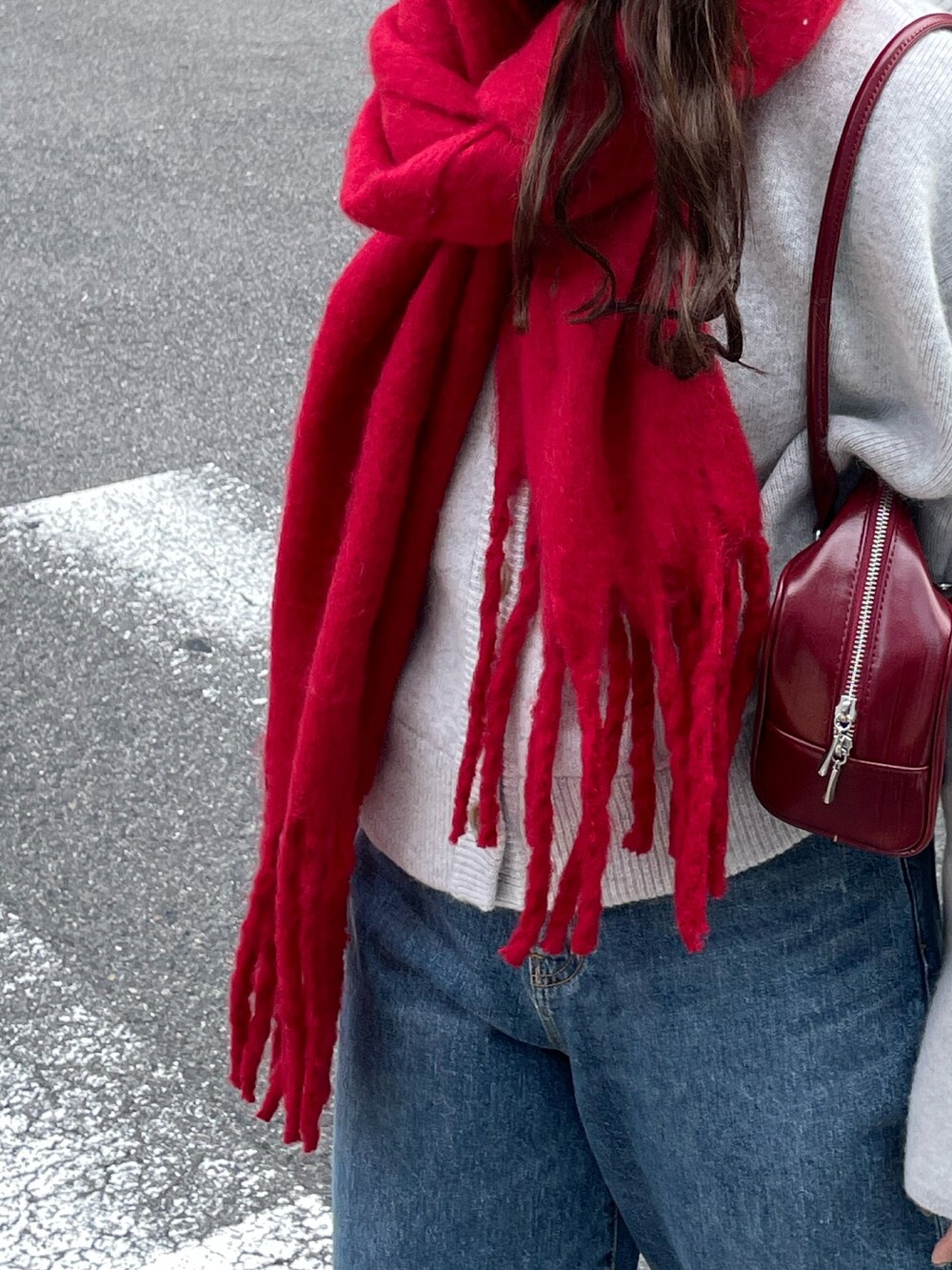 ブルー系のデニムパンツ、レッド系のハンドバッグ、グレー系のカーディガン/ボレロを着用したレディースの秋コーディネートの5枚目の写真